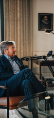 Koning Willem-Alexander tijdens de opnames van zijn podcast. Op de achtergrond het portret van Willem van Oranje.